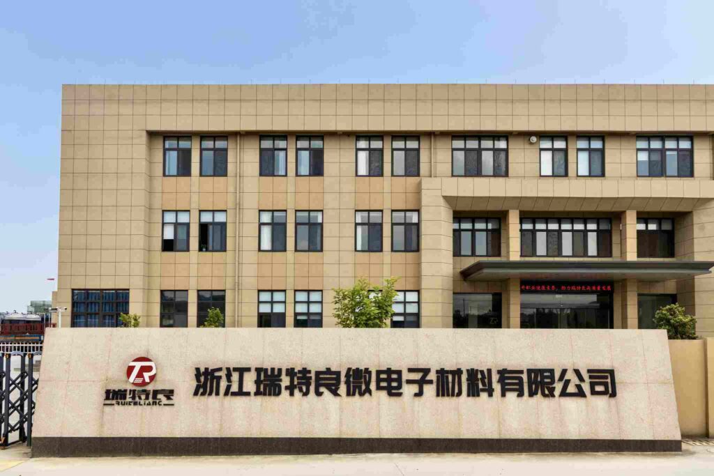 The exterior of a modern office building. The building facade is tan with multiple windows, and the RTL (Zhejiang Ruiteliang) name and logo are displayed on a sign at the entrance.